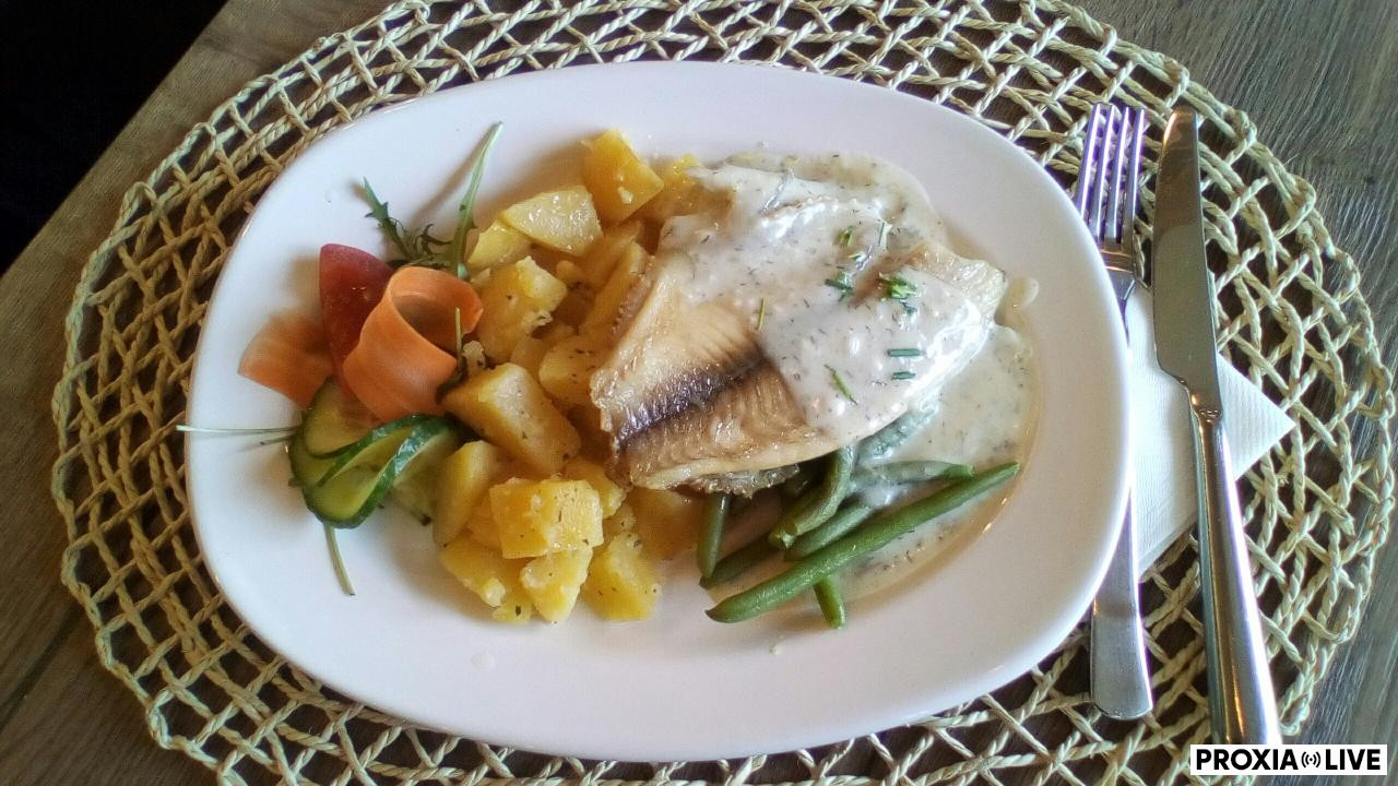 Tilapia na fazuľových strukoch preliata kôprovou omáčkou, podávaná so zemiakmi na masle 